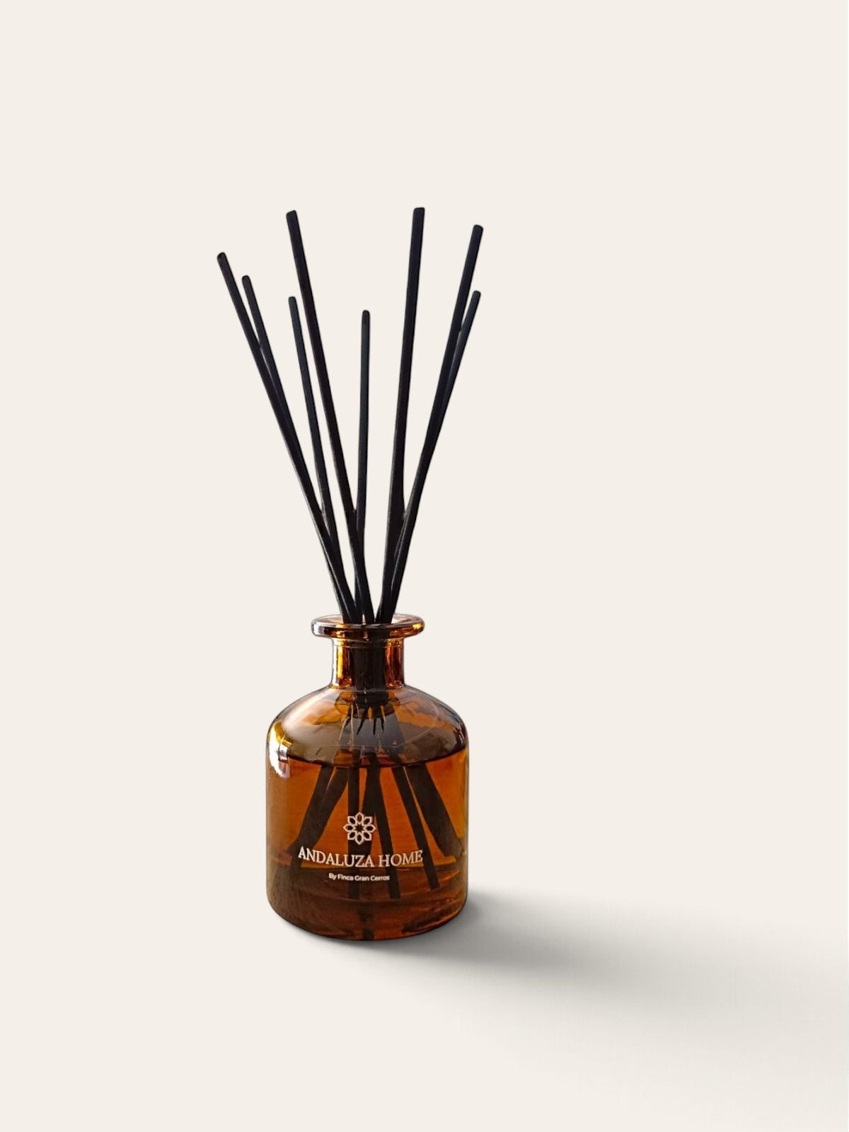 Amber glass reed diffuser bottle (200ml) with black reeds, featuring the brand name 'Andaluza Home  on the front, set against a solid off-white background.